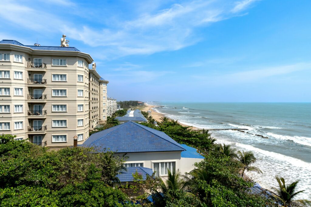 Oceanfront penthouse A luxurious beachfront resort overlooking the ocean with clear blue skies and sandy beaches.