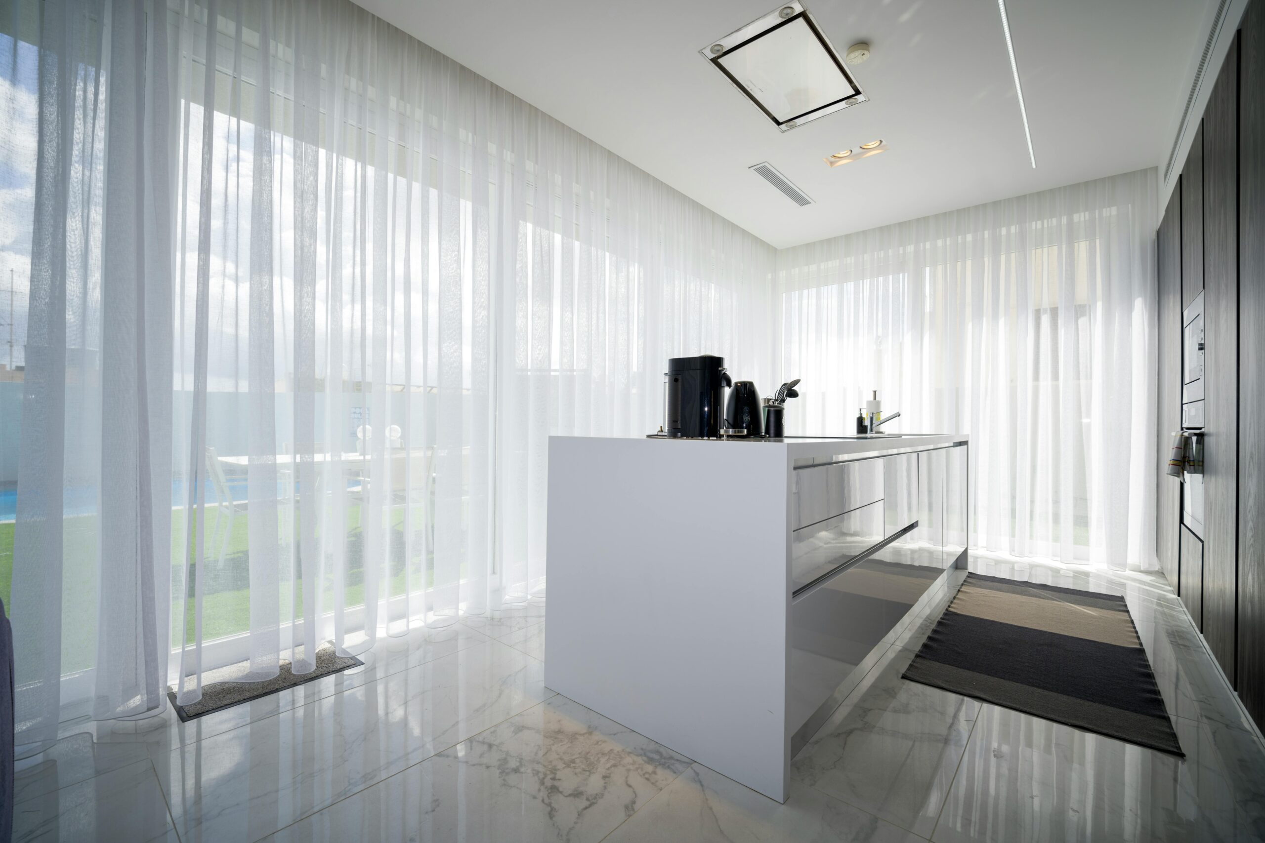 Bright modern kitchen with sheer curtains in a luxury villa located in St. Julian's, Malta.